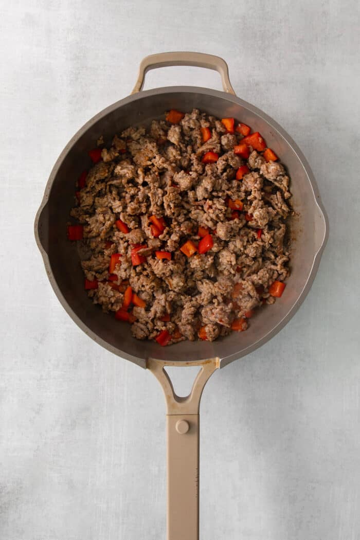 This gorgeously cheesy Sausage Dip takes a creamy base of Velveeta and sour cream and swirls it with spicy sausage and juicy corn kernels. Sausage browns in a skillet with red bell pepper.