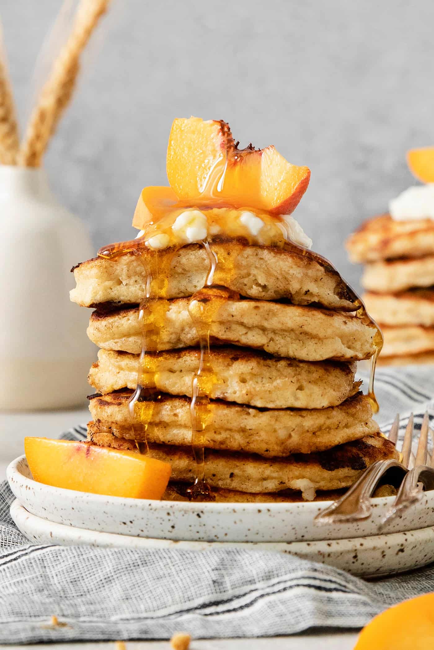 rotein-packed Cottage Cheese Pancakes are light and fluffy, flavored with cinnamon and vanilla, and rich and creamy from cottage cheese. A tall stack of cottage cheese pancakes on a plate is topped with sliced fresh peaches and maple syrup.