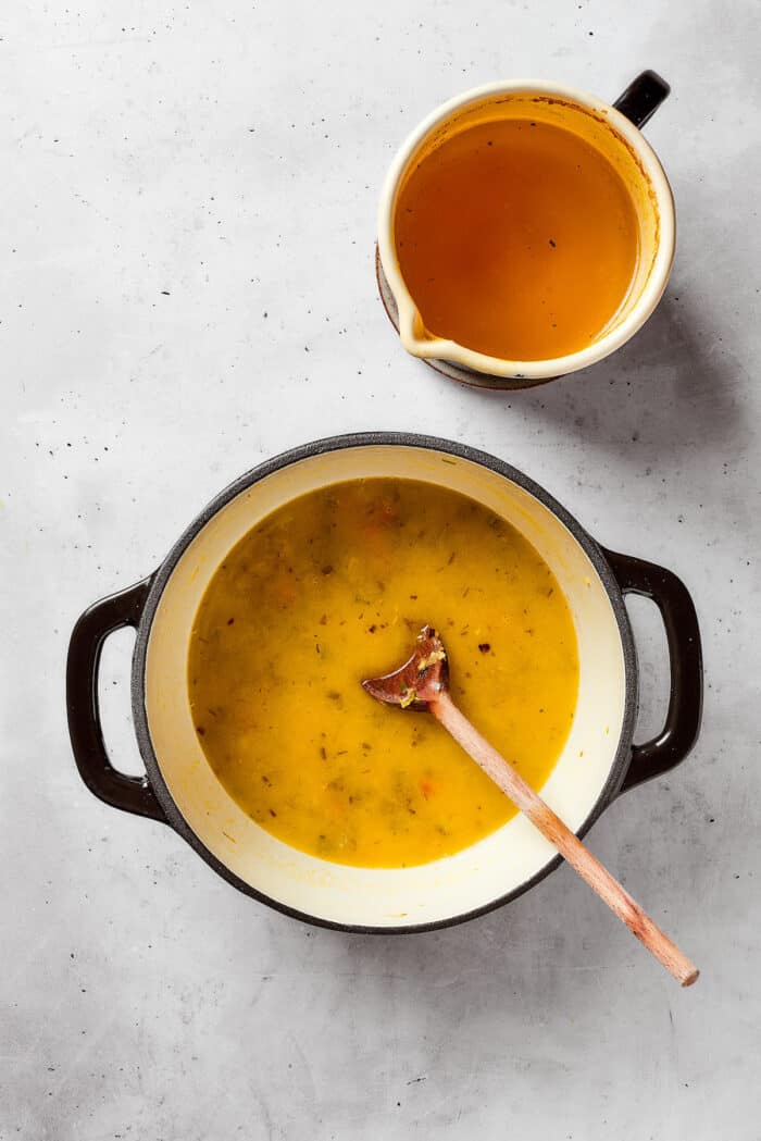 Greek-inspired Lemon Chicken Orzo Soup is fragrant with garlic and packed with tender chicken, vegetables, and delicate orzo pasta. Broth is added to apot of lemon chicken orzo soup.
