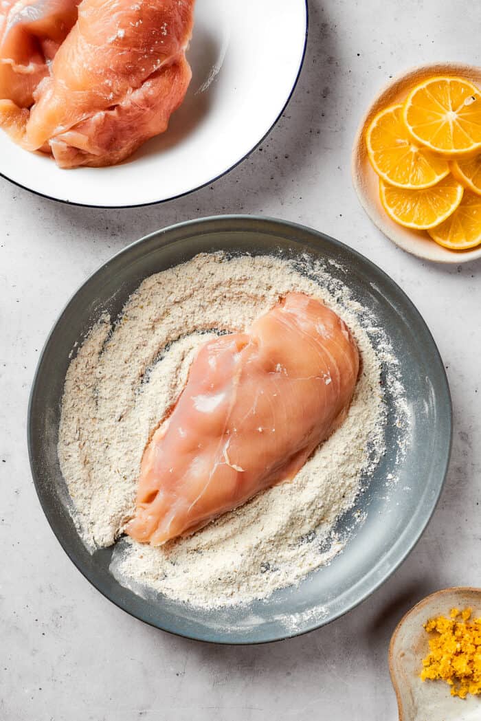 This juicy and tender Lemon Pepper Chicken recipe punches up ordinary chicken with a burst of bright, fresh lemon and a simple sauce. A piece of chicken breast is dredged through a cornstarch mixture.