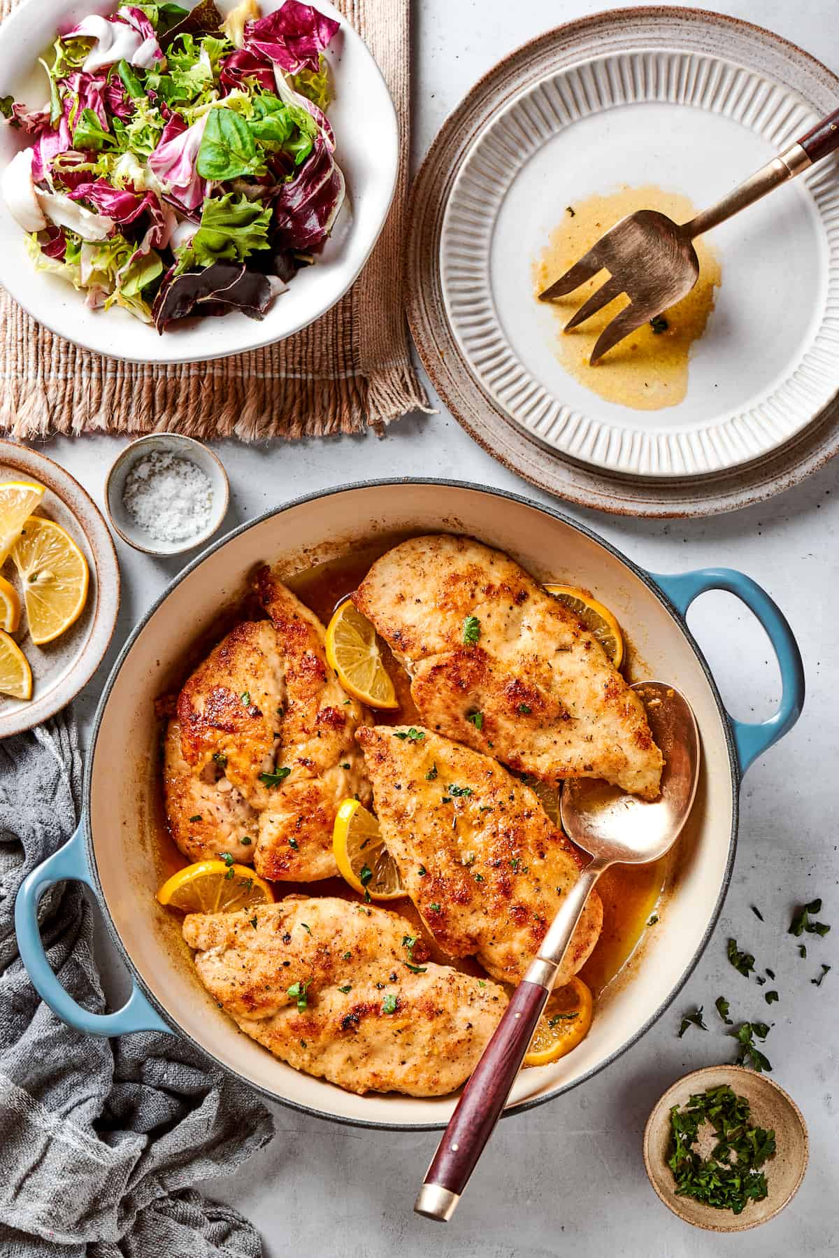 This juicy and tender Lemon Pepper Chicken recipe punches up ordinary chicken with a burst of bright, fresh lemon and a simple sauce. A dutch oven of lemon pepper chicken on a table.
