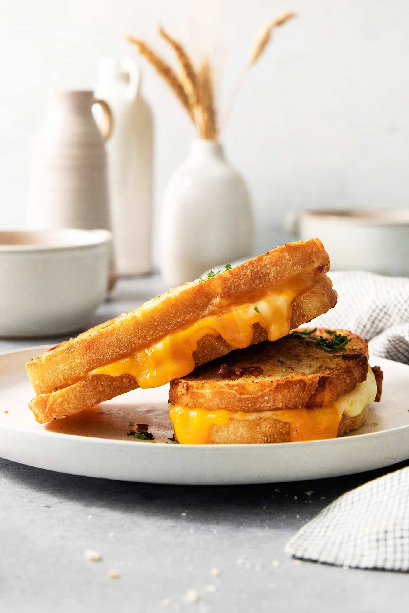 Air Fryer Grilled Cheese | Easy Cheesy Grilled Cheese Recipe! Two pieces of air fryer grilled cheese on a white plate.