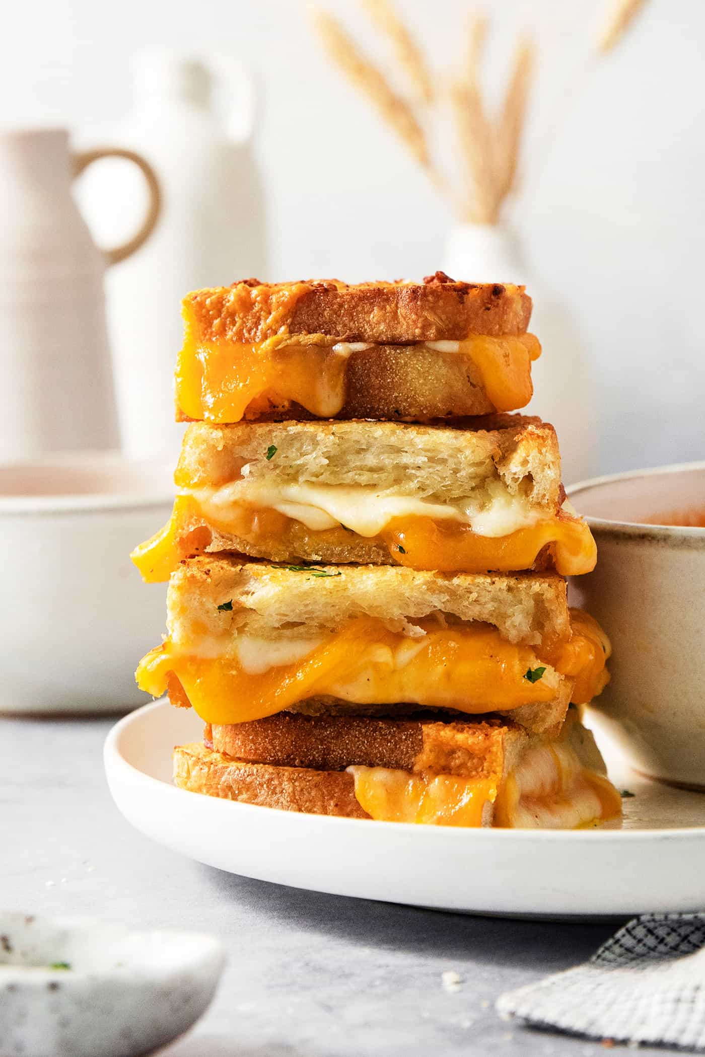 Air Fryer Grilled Cheese | Easy Cheesy Grilled Cheese Recipe! A stack of slices of air fryer grilled cheese sandwiches shows the melted cheese inside.