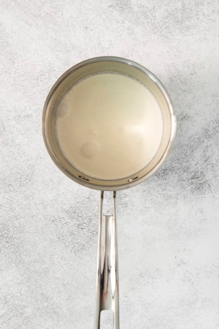 This easy Chocolate Ganache recipe is a versatile staple, perfect for so many things – from cakes to tart fillings to drizzling over coffee! Heavy cream heats in a pot.