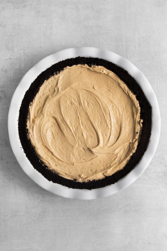This no-bake Reese’s Pie features a crisp Oreo crust and a creamy peanut butter filling finished with whipped topping and Reese’s cups. Peanut filling is added to the crust and the top is smoothed.