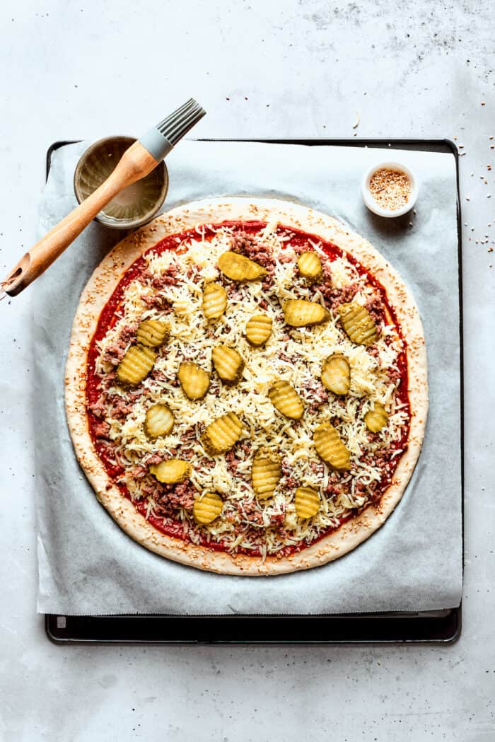 The cheeseburger pizza is ready to be baked.