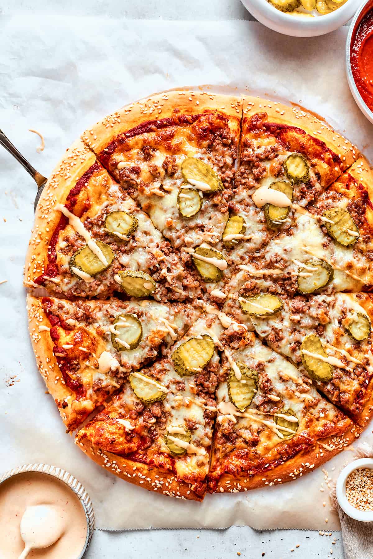 This Cheeseburger Pizza recipe turns your favorite burger into pizza! Top homemade dough with pizza sauce, ground beef, cheese, and pickles. A freshly baked cheeseburger pizza topped with meat and pickles.