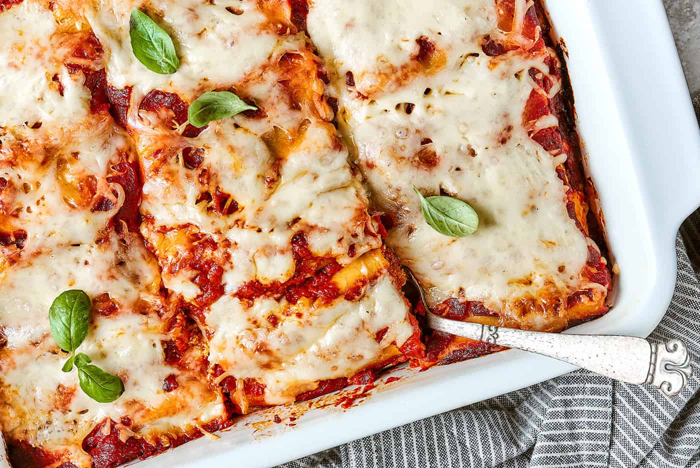 a white baking dish with rolls of lasagna