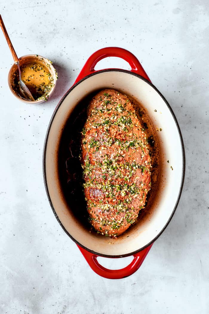 This ultra-juicy Sirloin Tip Roast recipe makes perfectly tender meat every time with plenty of garlic and fresh herbs for added flavor. The seasoned roast is show in in the baking dish.