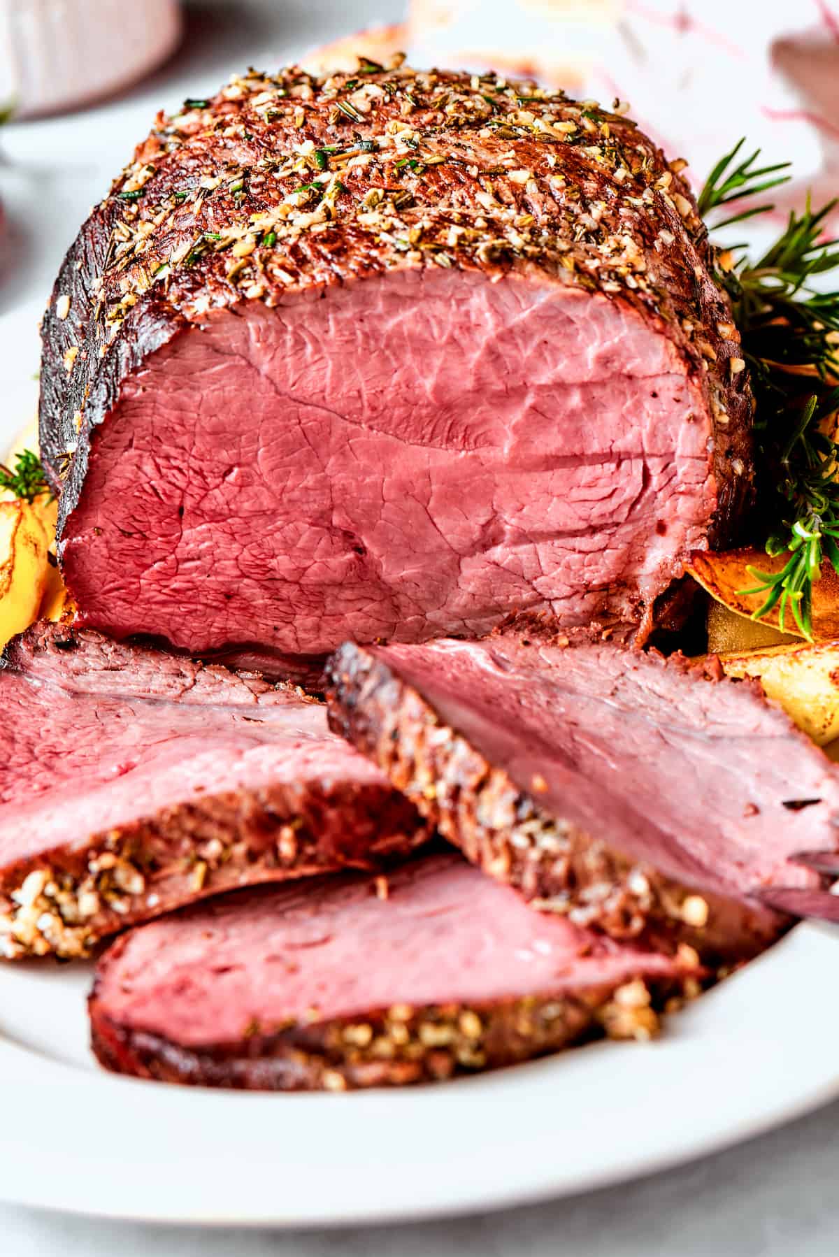 This ultra-juicy Sirloin Tip Roast recipe makes perfectly tender meat every time with plenty of garlic and fresh herbs for added flavor. A sirloin tip roast on a platter with slices of roast.