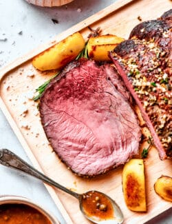 A pink slice of sirloin tip roast is cut from the whole roast.