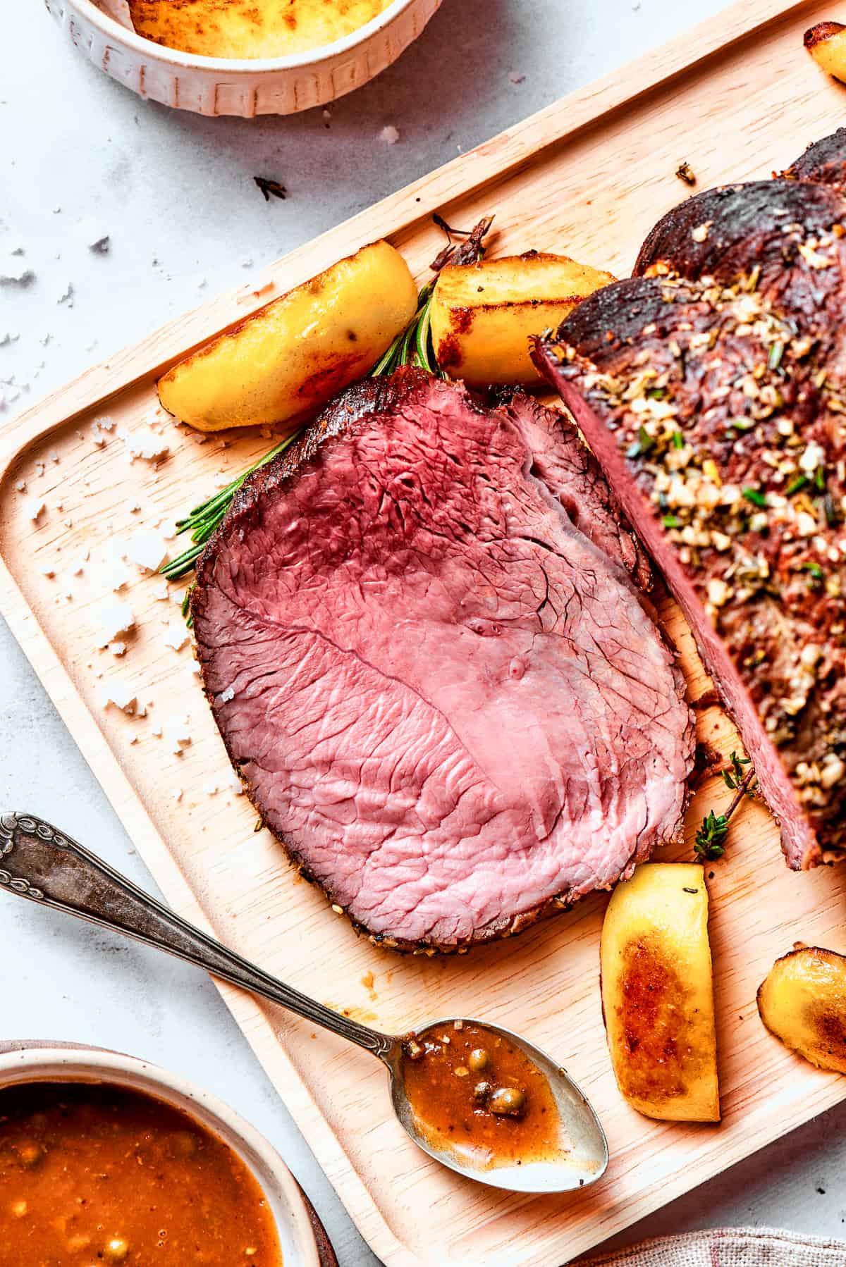 This ultra-juicy Sirloin Tip Roast recipe makes perfectly tender meat every time with plenty of garlic and fresh herbs for added flavor. A pink slice of sirloin tip roast is cut from the whole roast.