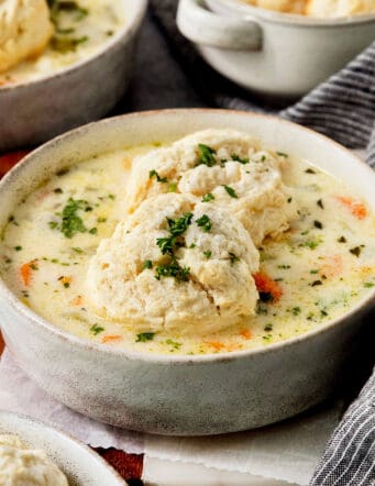 Tender biscuits atop a bowl of chicken pot pie soup.