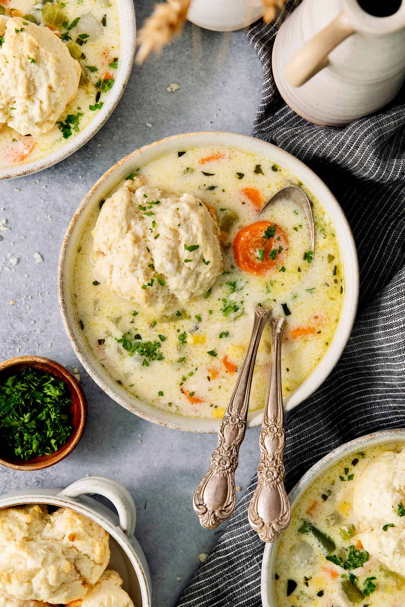 This homemade Chicken Pot Pie Soup recipe features a creamy broth that’s loaded with chicken and vegetables and topped with biscuits. A bowl of chicken pot pie soup with a biscuit floating on the top.
