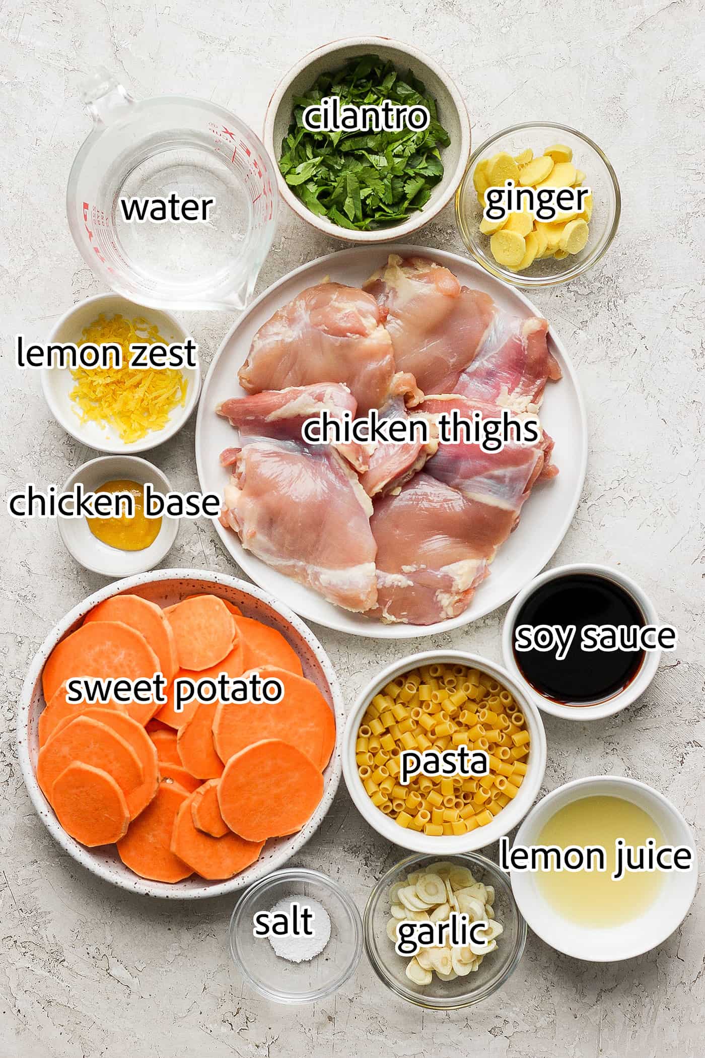 This zesty Chicken Ginger Soup recipe is brimming with fresh ginger, garlic, and lemon plus sweet potatoes, shredded chicken, and pasta. Ingredients needed to make ginger chicken soup include chicken thighs, sweet potatoes, lemon zest and juice, garlic, ginger, soy sauce, pasta, water, salt and pepper.