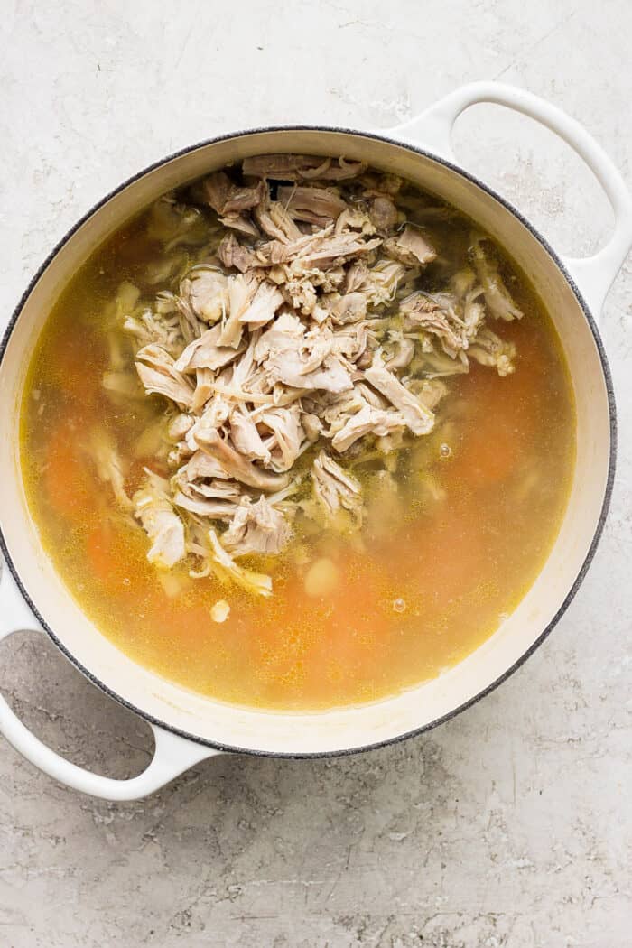 This zesty Chicken Ginger Soup recipe is brimming with fresh ginger, garlic, and lemon plus sweet potatoes, shredded chicken, and pasta. The shredded chicken is added into the soup.