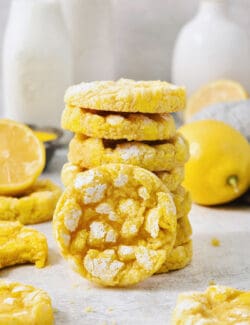 A stack of yellow lemon crinkle cookies with one turned on its side.