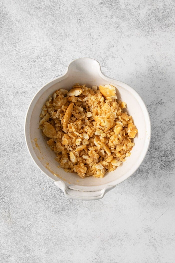 This easy Pineapple Casserole is a sweet and savory southern-inspired dish combining pineapple with cheese that pairs perfectly with BBQ. Crushed ritz crackers in a white bowl.