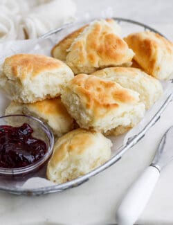 Touch of grace biscuits in a wire basket with a dish of jam.