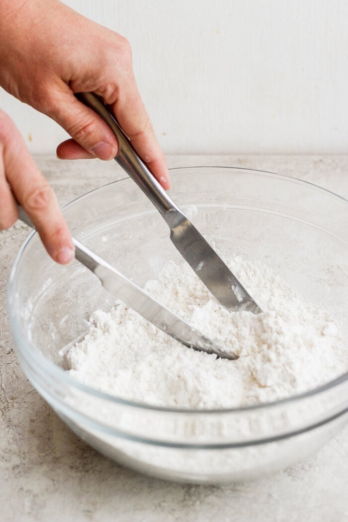 Flaky and light Touch of Grace Biscuits are made with White Lily flour to make unbelievably tender pull-apart biscuits. Hands use mixing utensils to mix the biscuit dough.