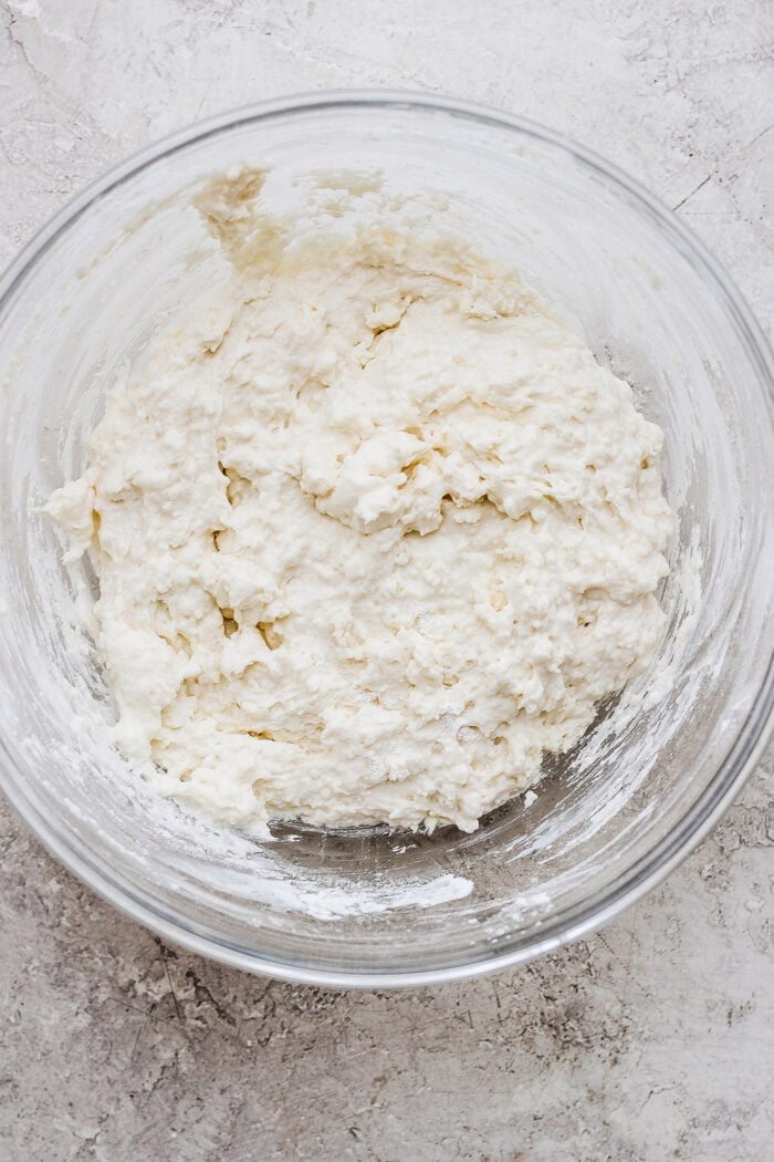Flaky and light Touch of Grace Biscuits are made with White Lily flour to make unbelievably tender pull-apart biscuits. Crumbly touch of grace biscuit dough is shown in a glass bowl.