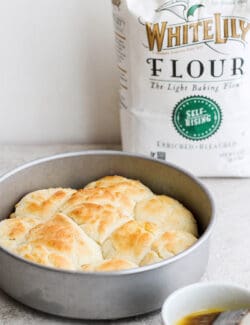 A bag of White Lily flour is seen in the background with baked touch of grace biscuits in a baking tin in the foreground.