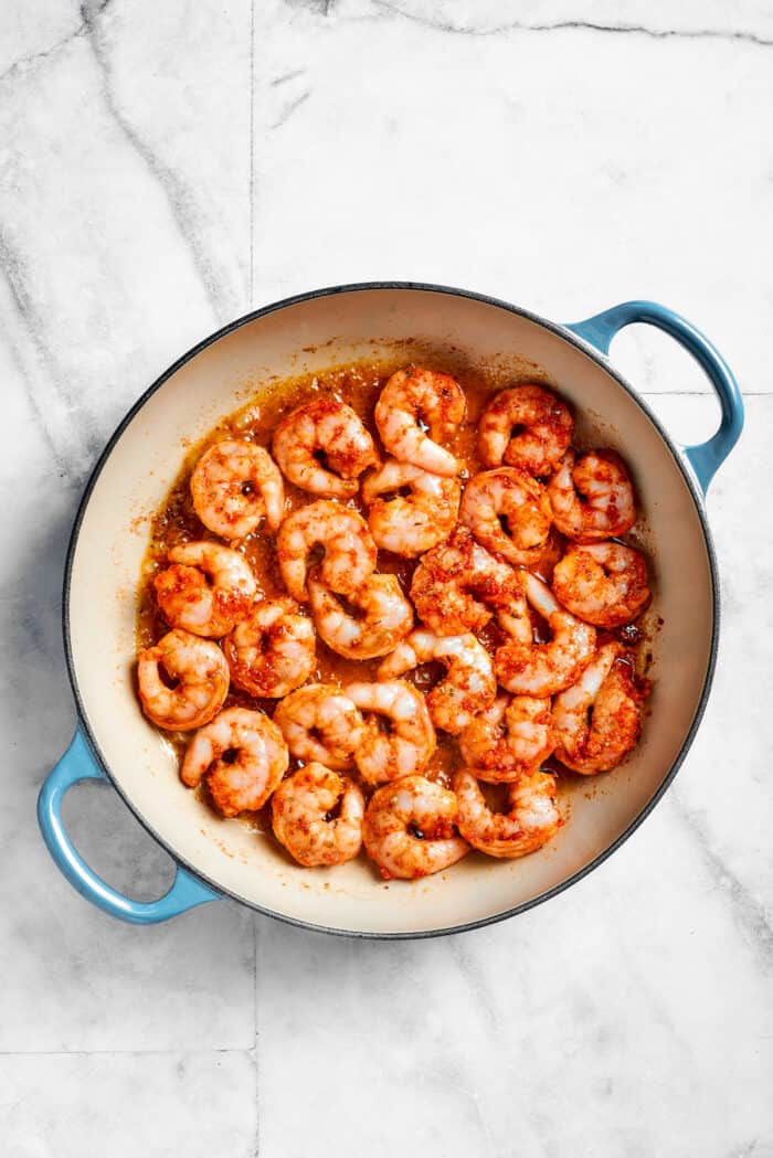 This beautiful, smoky-spicy Cajun Shrimp Pasta recipe folds juicy shrimp into a creamy, Louisiana-inspired sauce. Shrimp cooks in a pot for cajun shrimp pasta.