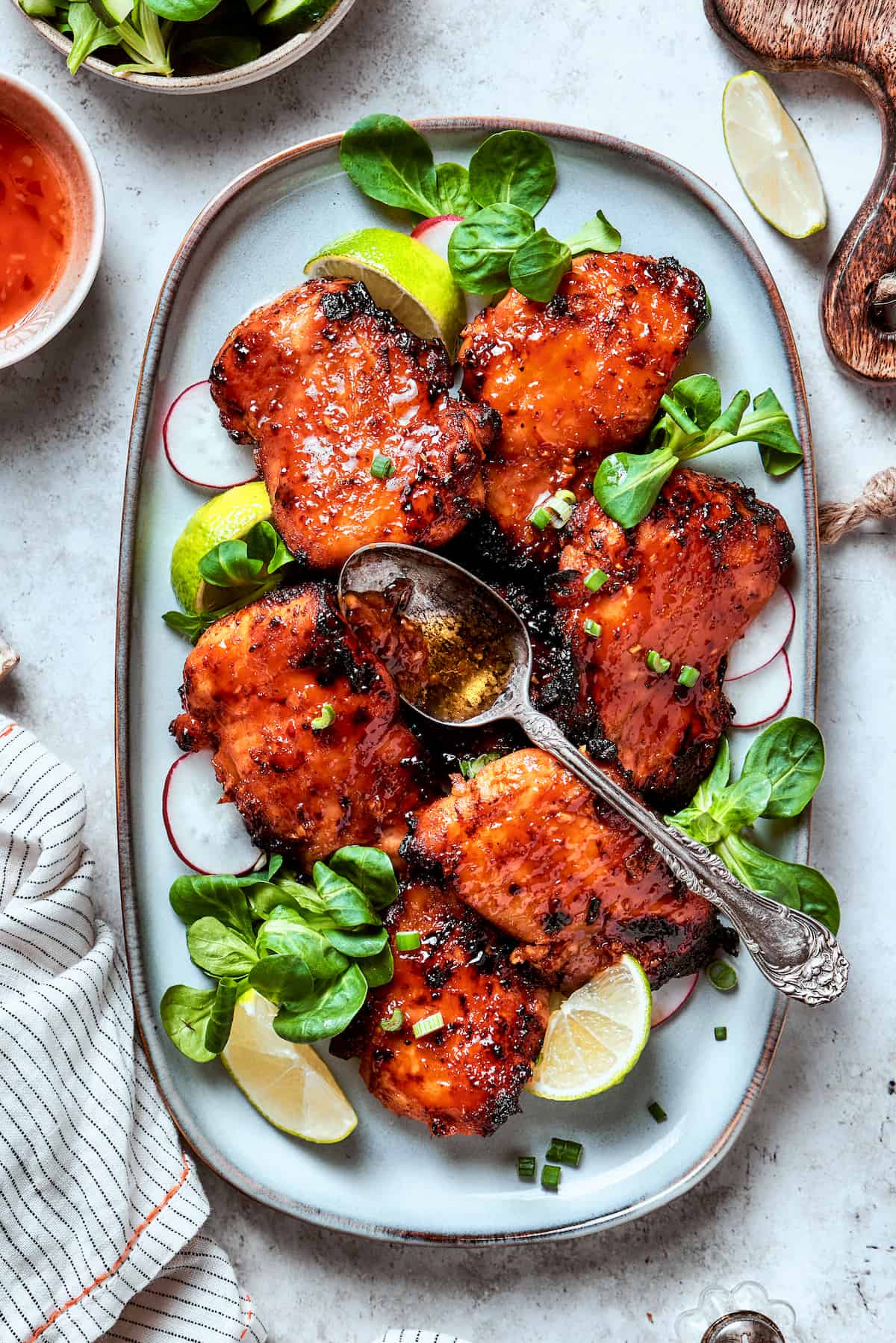 A big platter of lemongrass chicken with a spoon holding sauce resting on the top.