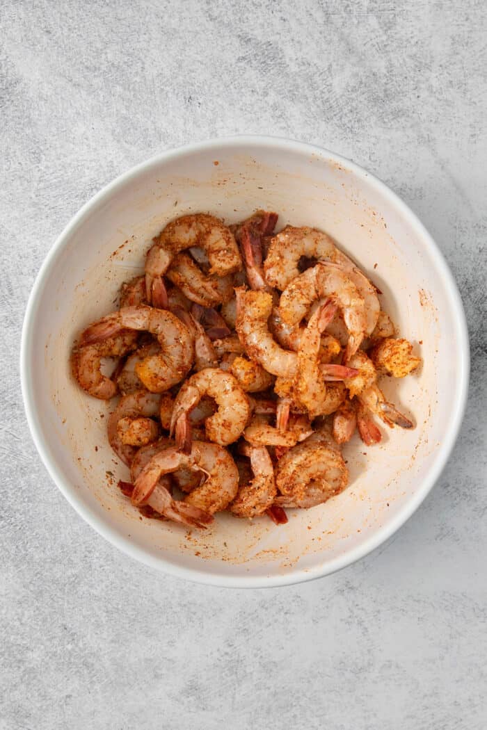 This Blackened Shrimp recipe makes a versatile protein that's ready in less than 10 minutes featuring juicy-crisp, well seasoned shrimp. A bowl of shrimp with seasoning.