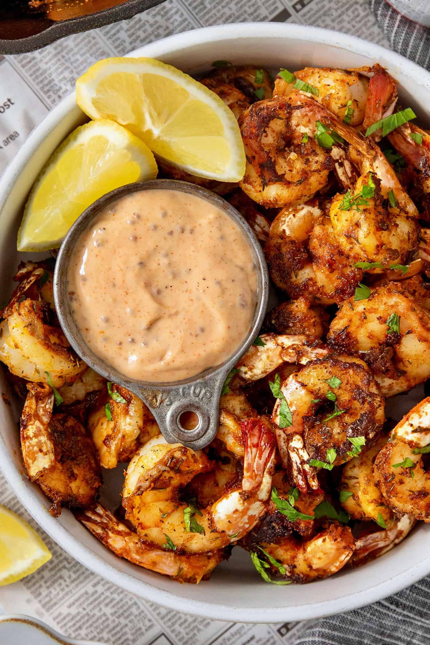 This Blackened Shrimp recipe makes a versatile protein that's ready in less than 10 minutes featuring juicy-crisp, well seasoned shrimp. A bowl of blackened shrimp is served with shrimp dipping sauce and lemon wedges.