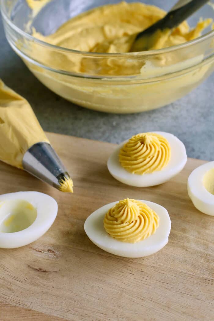 This Classic Deviled Eggs recipe is a beloved appetizer that features an irresistibly creamy and tangy filling made with simple basics. Make this easy deviled eggs recipe as written or try some of my flavorful variation suggestions. Deviled egg filling is piped into hard boiled egg whites.