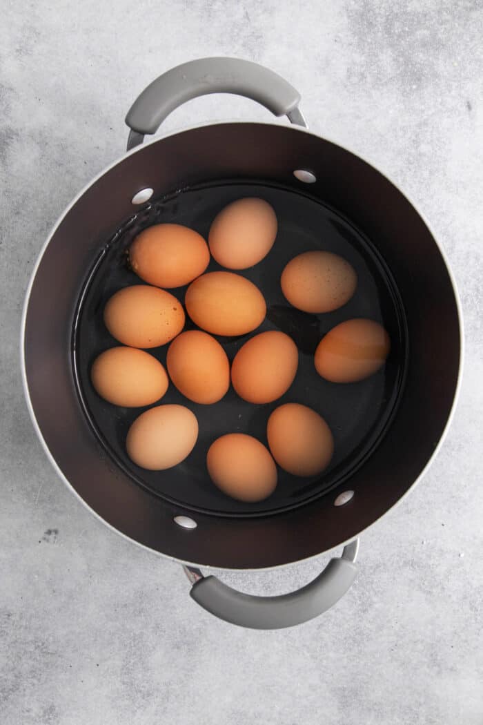 a dozen eggs cooking in a large pot