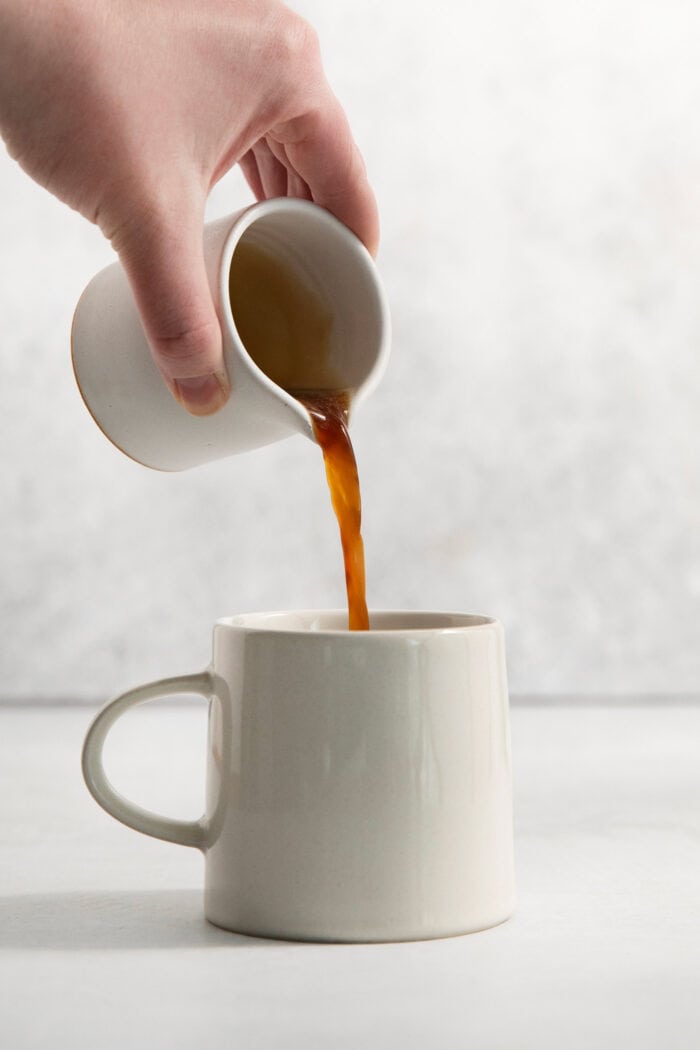 This Lavender Latte mixes freshly brewed espresso, oat milk, and a sweet lavender simple syrup to create a copycat Starbucks lavender latte. Espresso is poured into the mug.