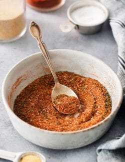 dried spices and herbs in a bowl, with a spoon