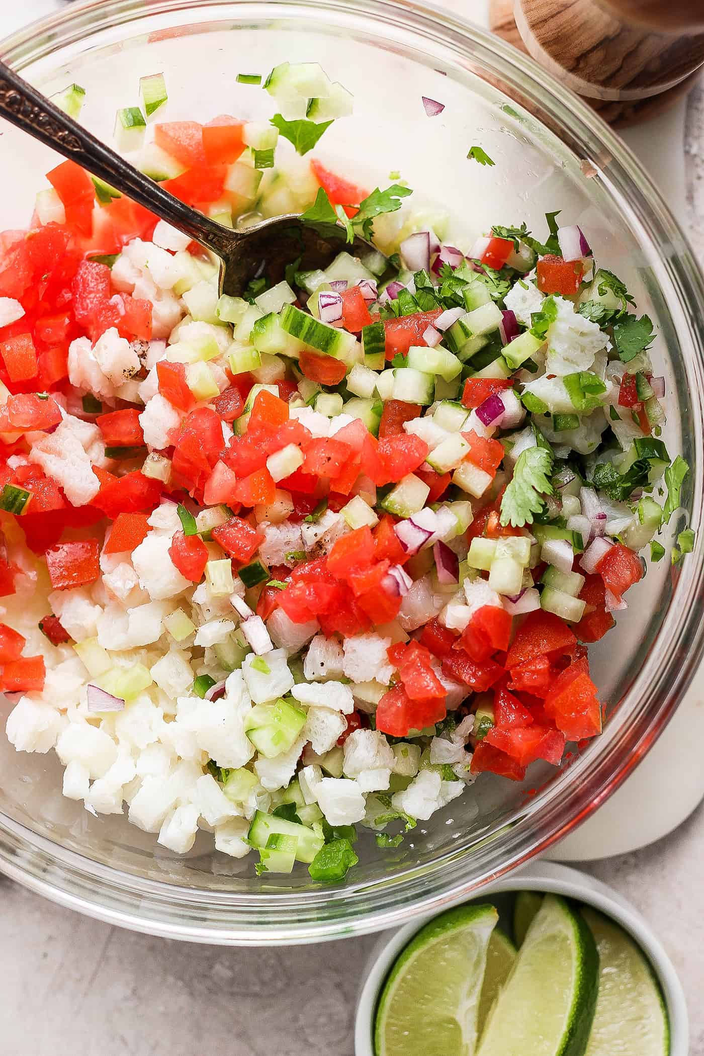 This refreshing Classic Ceviche recipe marinates fresh fish in lime and orange juices, then adds a mix of fresh veggies and a bit of jalapeno. The classic ceviche ingredients are mixed together in a bowl.