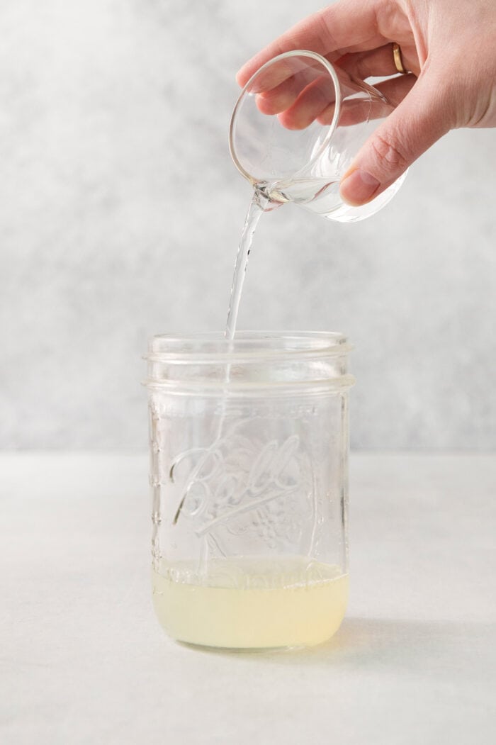 This Classic Margarita recipe makes the perfect tequila cocktail! Learn how to make a margarita that's always crisp, cold, and refreshing. Orange liqueur is poured into the jar.