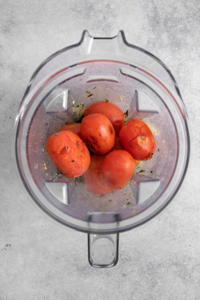This Warm Salsa recipe is perfectly spiced and juicy, with a pop of lime juice for sweetness. Enjoy it with tacos, quesadillas, & chips. Tomatoes are placed in a blender.