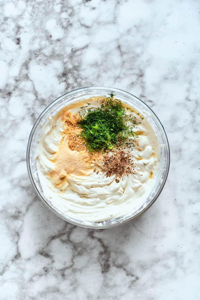 This cold and creamy Dill Pickle Dip is packed with crunchy pickles and a mix of cream cheese and sour cream. The rest of the ingredients except for the pickles and chips are added.