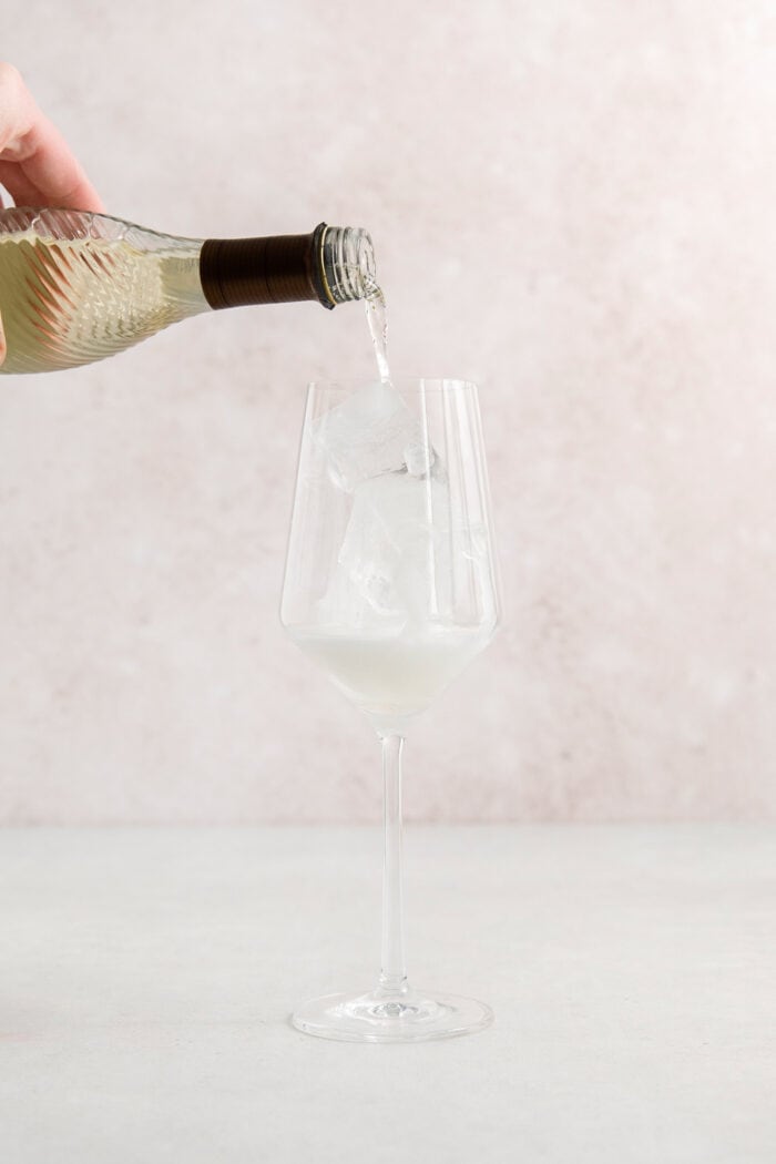 This classic Aperol spritz recipe is my take on an Italian aperitivo and makes a refreshing cocktail out of just four ingredients. Procecco is poured into a wine glass.