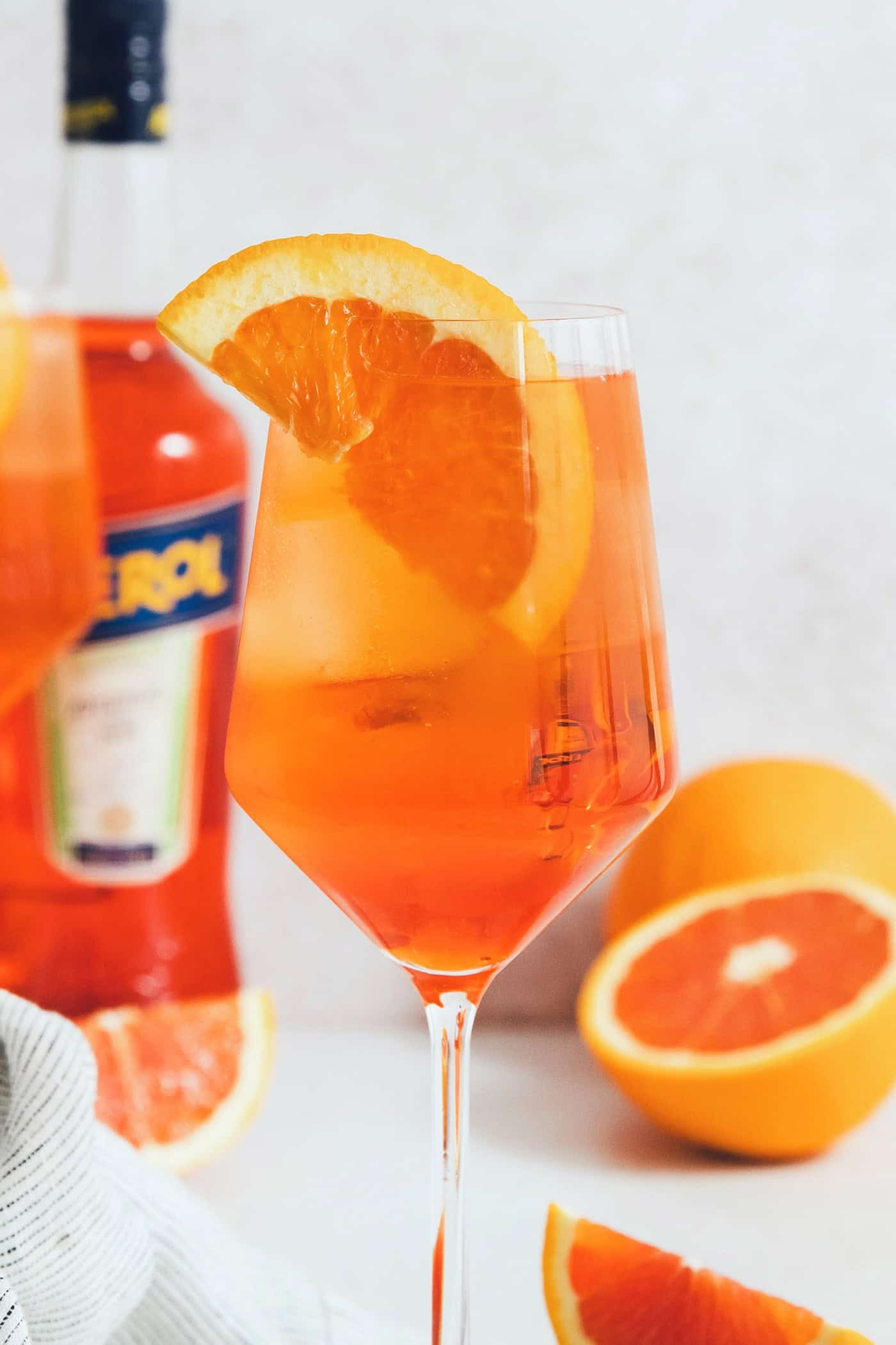 This classic Aperol spritz recipe is my take on an Italian aperitivo and makes a refreshing cocktail out of just four ingredients. An orange wedge garnishes a wine glass of Aperol spritz.