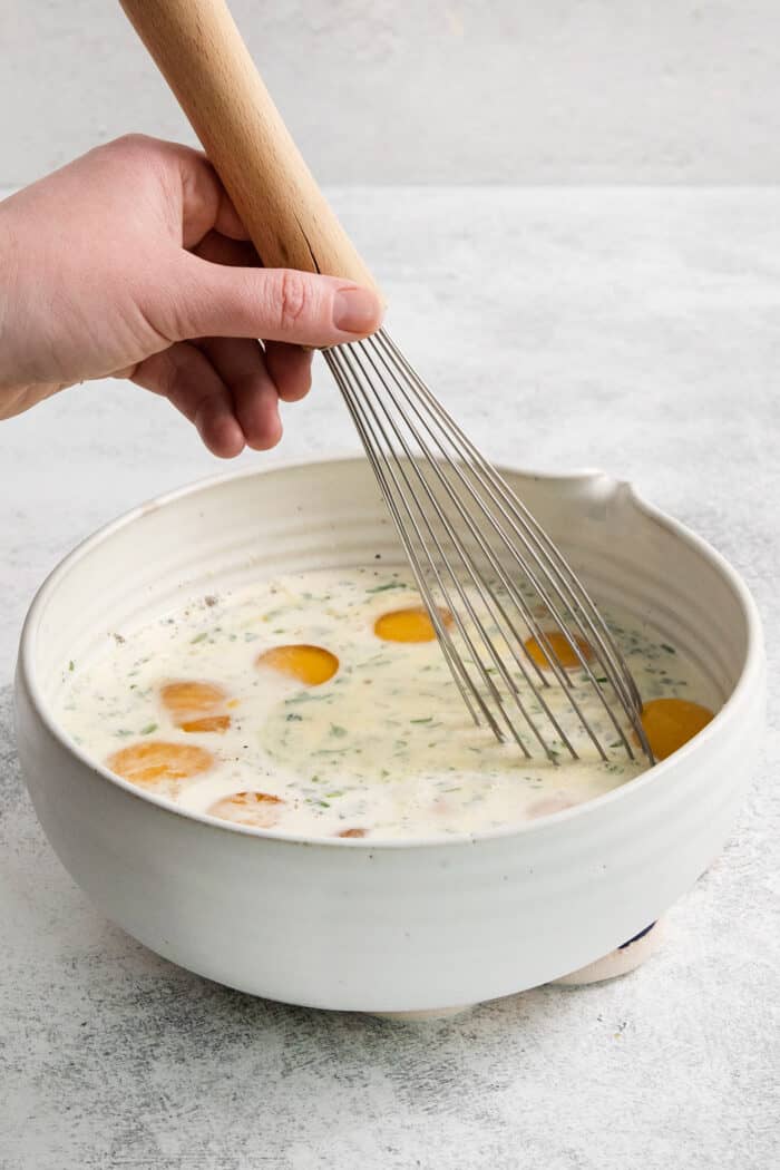 Soft and savory Baked Eggs are a welcome addition to the brunch table. Loaded with salty pancetta, melted provolone, and peas. Eggs are whisked with cream in a bowl for baked eggs.