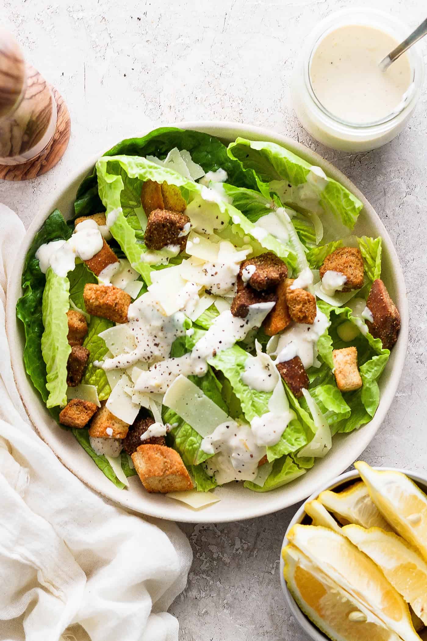 A big bowl of caesar salad topped with homemade caesar dressing.