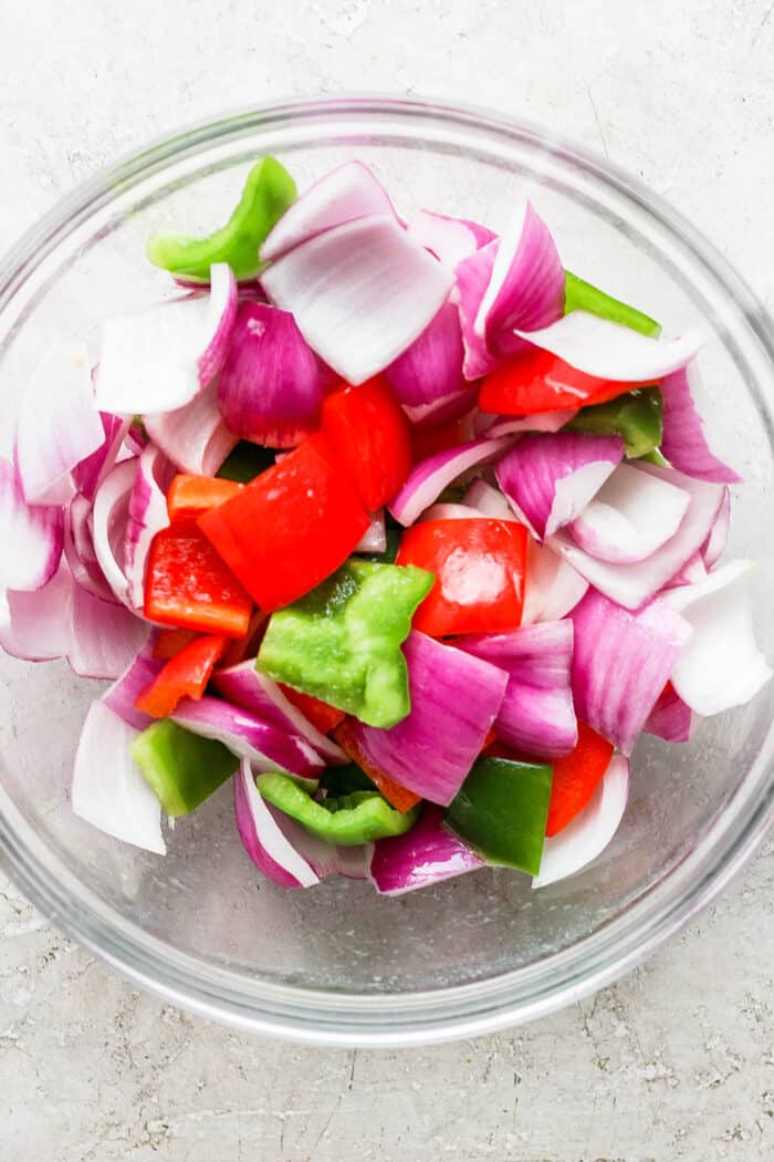 The onion and peppers are added to a bowl.