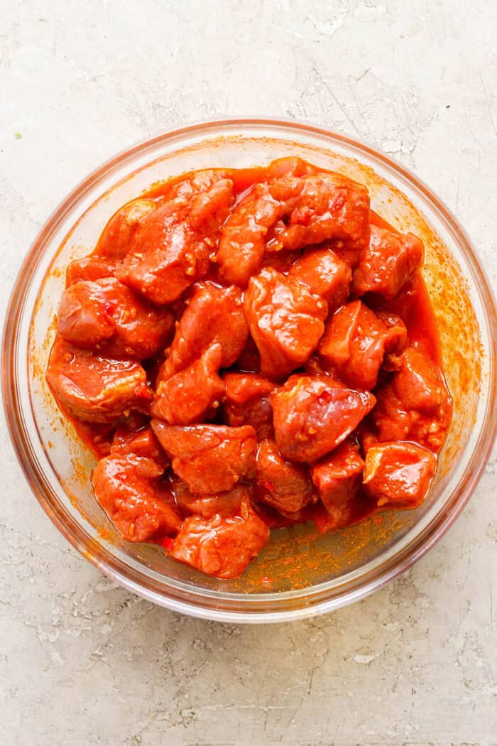 Pork pieces marinate in a bowl.