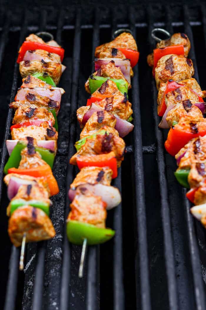 Chermoula pork kabobs cook on a grill.