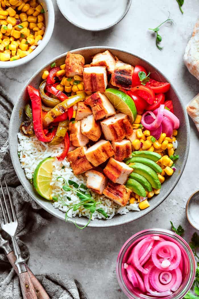 Juicy Honey Mustard Chicken Kabobs are slicked in a smoky honey mustard sauce and cooked to perfection on the grill. a chicken fajita bowl with rice, corn salsa, pickled red onions, peppers, and avocado