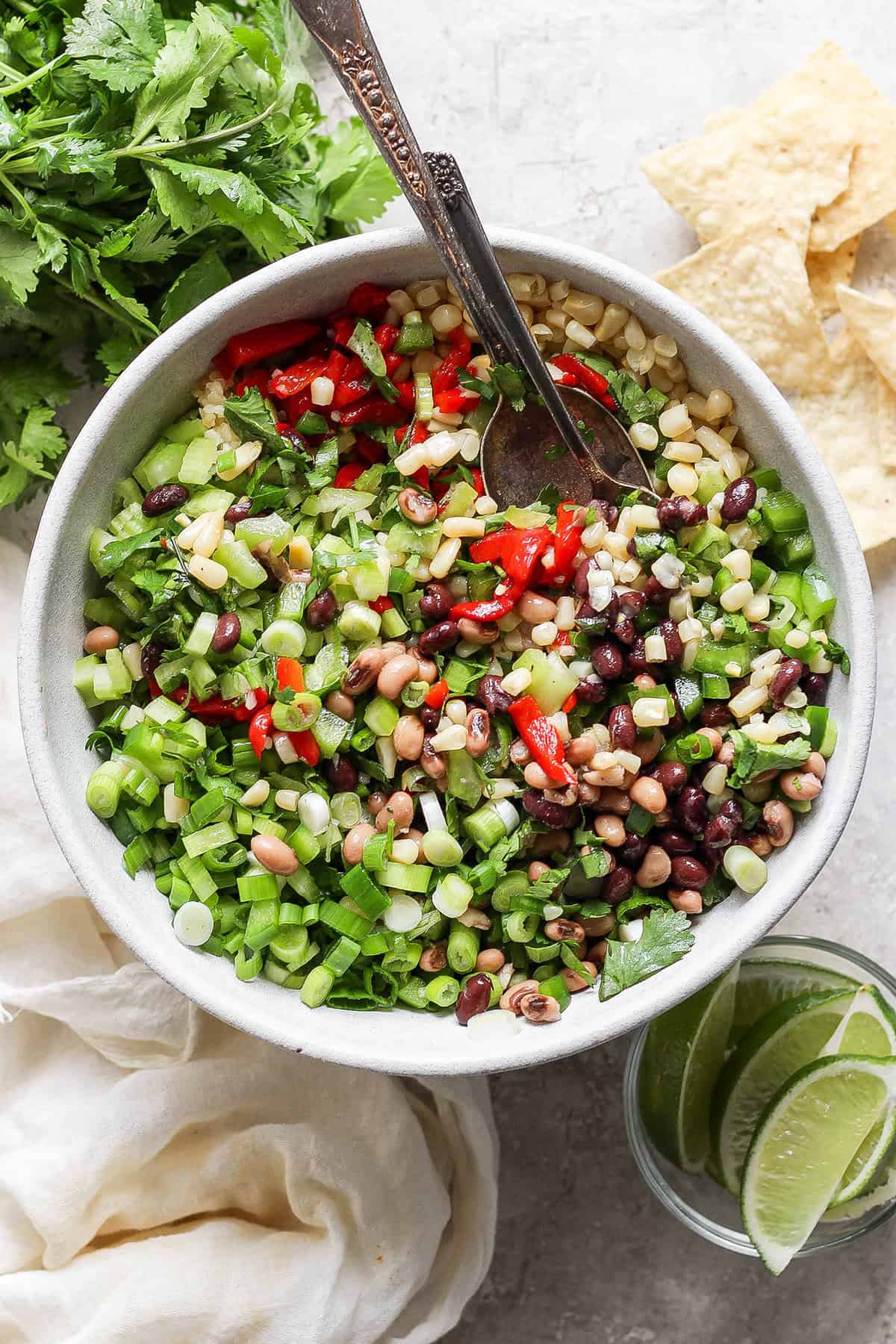A big bowl of cowboy caviar with a serving spoon.