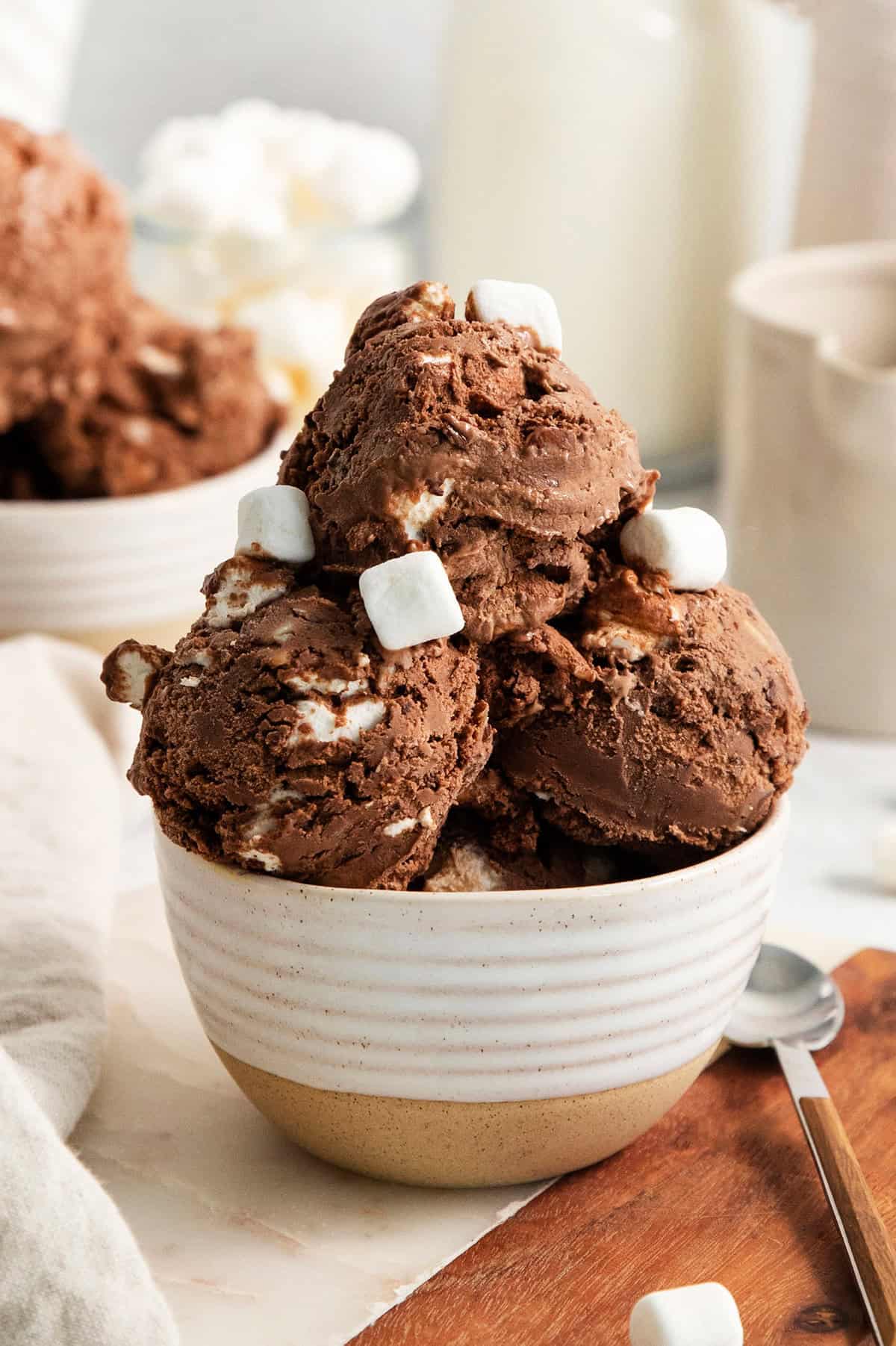 Rocky Road Ice Cream stars a creamy chocolate custard base that's loaded with almonds, marshmallows, and even more chocolate! A few mini marshmallows adorn scoops of rocky road ice cream in a bowl.