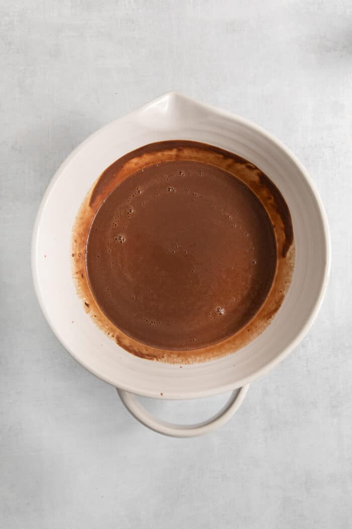 Rocky Road Ice Cream stars a creamy chocolate custard base that's loaded with almonds, marshmallows, and even more chocolate! The chocolate ice cream base is shown in a bowl.