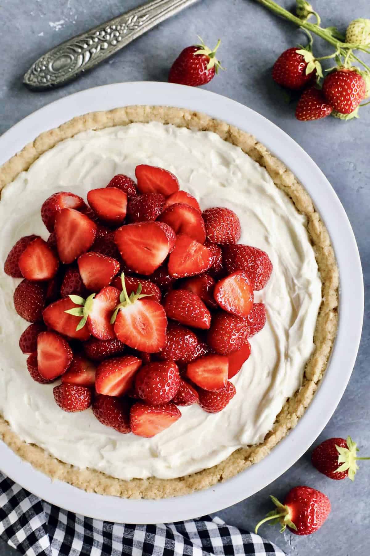 overhead photo of cream cheese pie with fresh strawberries, in a white pie plate